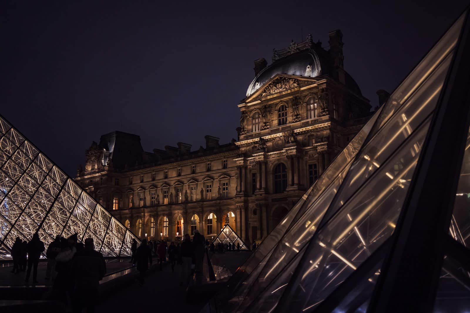 A very tall building with a very tall pyramid in front of it