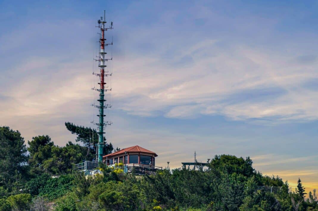 A very tall tower sitting on top of a lush green hillside