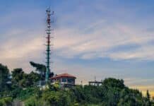 A very tall tower sitting on top of a lush green hillside