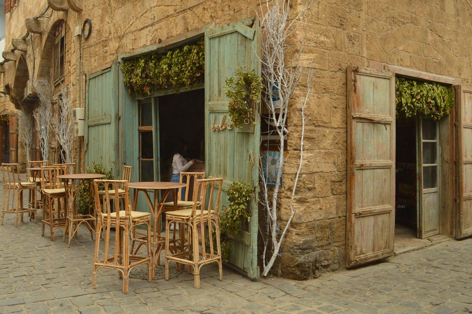 Dans la presse: Le Liban des années 60 doit renaître a man standing outside of a building next to tables and chairs