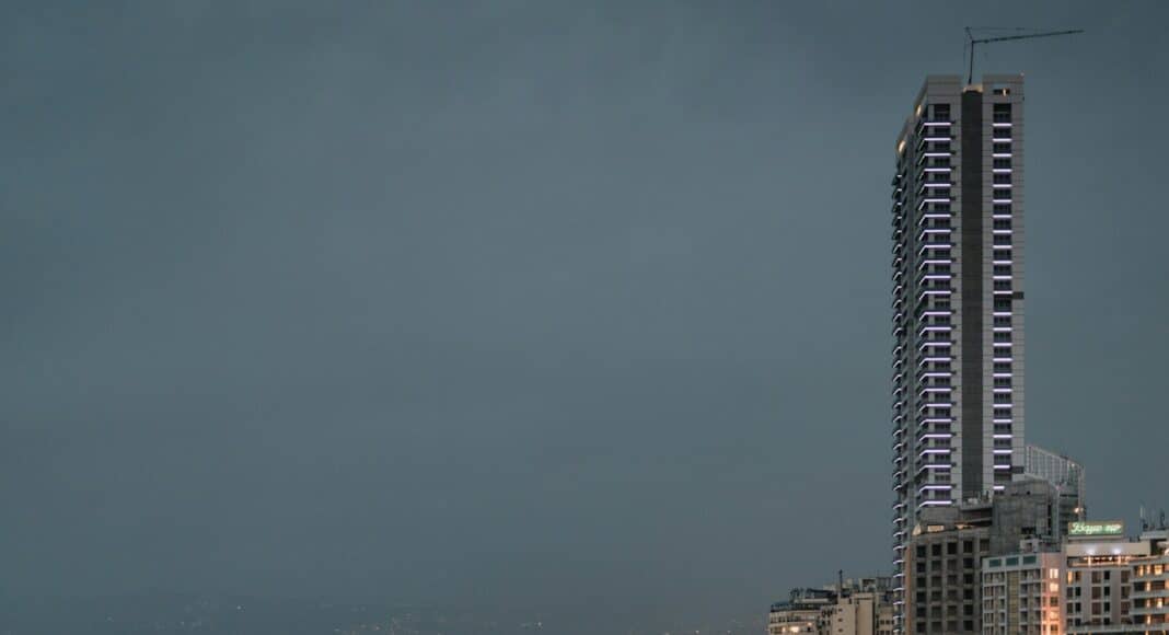 city skyline across body of water during night time