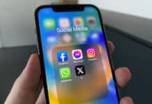 a person holding a cell phone with social media on the screen