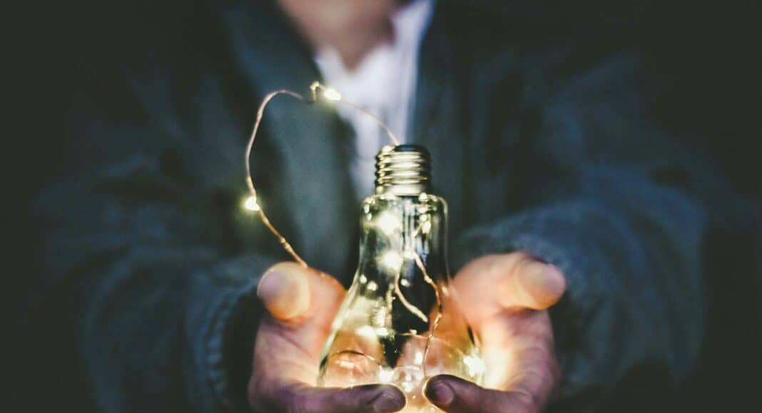 man holding incandescent bulb