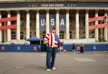 A man standing in front of a large building