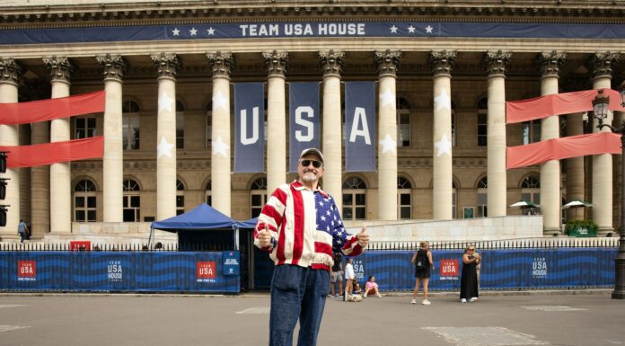 A man standing in front of a large building