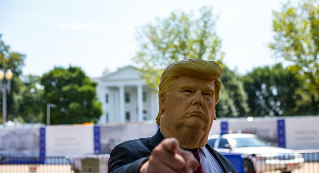 man wearing Donald Trump mask standing in front of White House