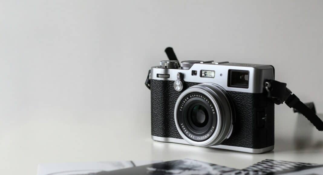 black and gray film camera near printed photos