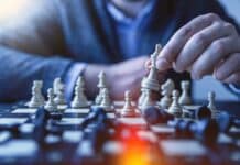 depth of field photography of man playing chess