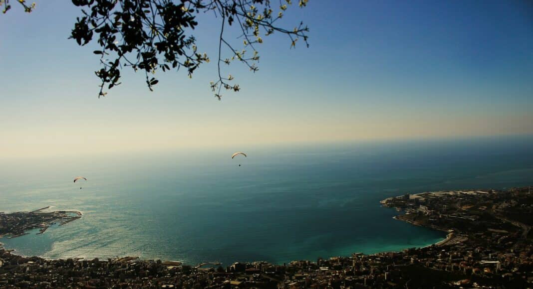 a view of the ocean and a city from a hill