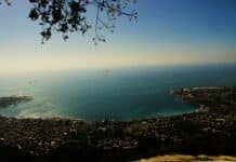a view of the ocean and a city from a hill