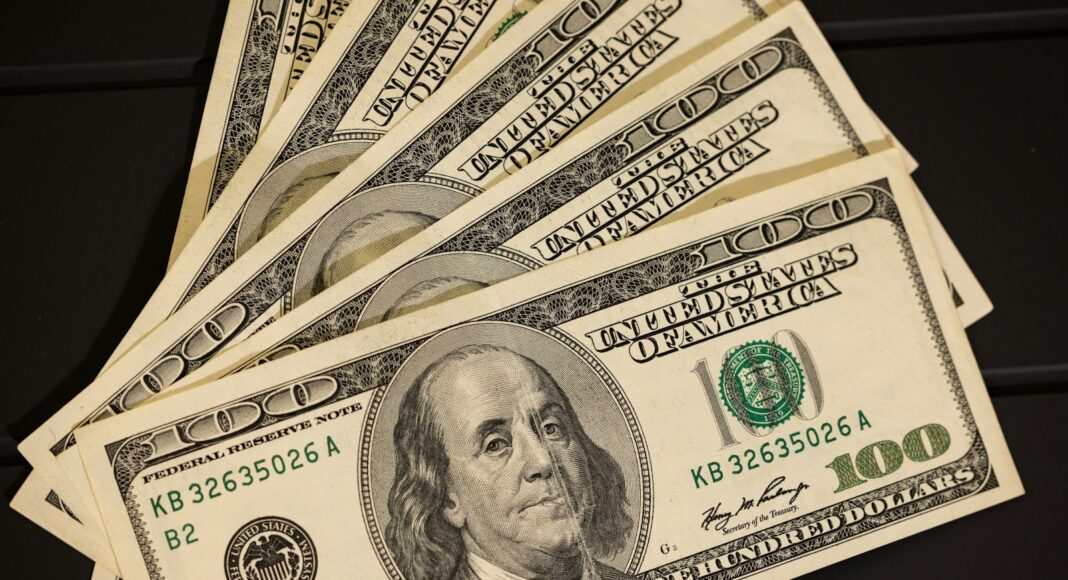 a stack of twenty dollar bills sitting on top of each other