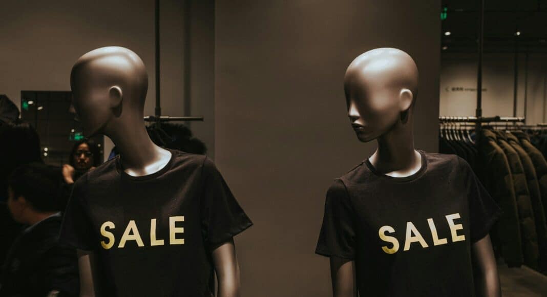 two mannequins with black Sale graphic crew-neck t-shirts