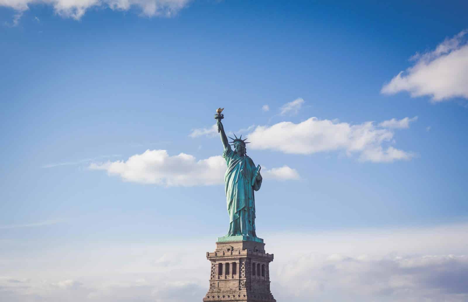 L’administration Trump suspend l’USAID et gèle l’aide humanitaire mondiale Statue of Liberty, New York under white and blue cloudy skies
