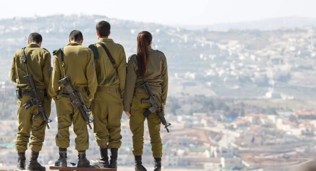 three men and one woman soldiers standing on rock during daytime