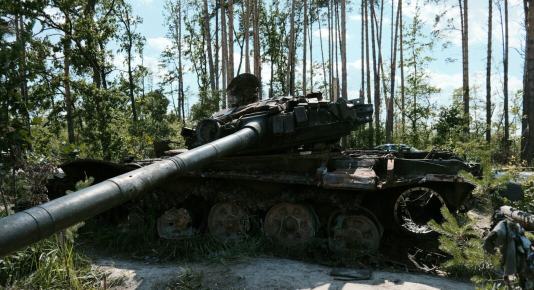 an old tank sitting in the middle of a forest