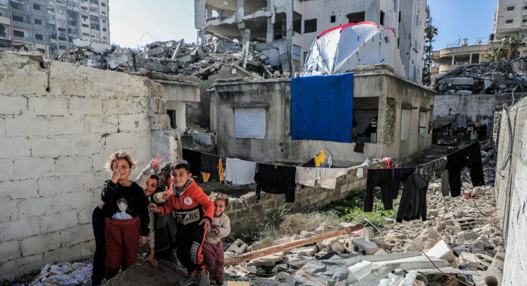 A group of people standing next to a pile of rubble