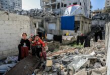 A group of people standing next to a pile of rubble