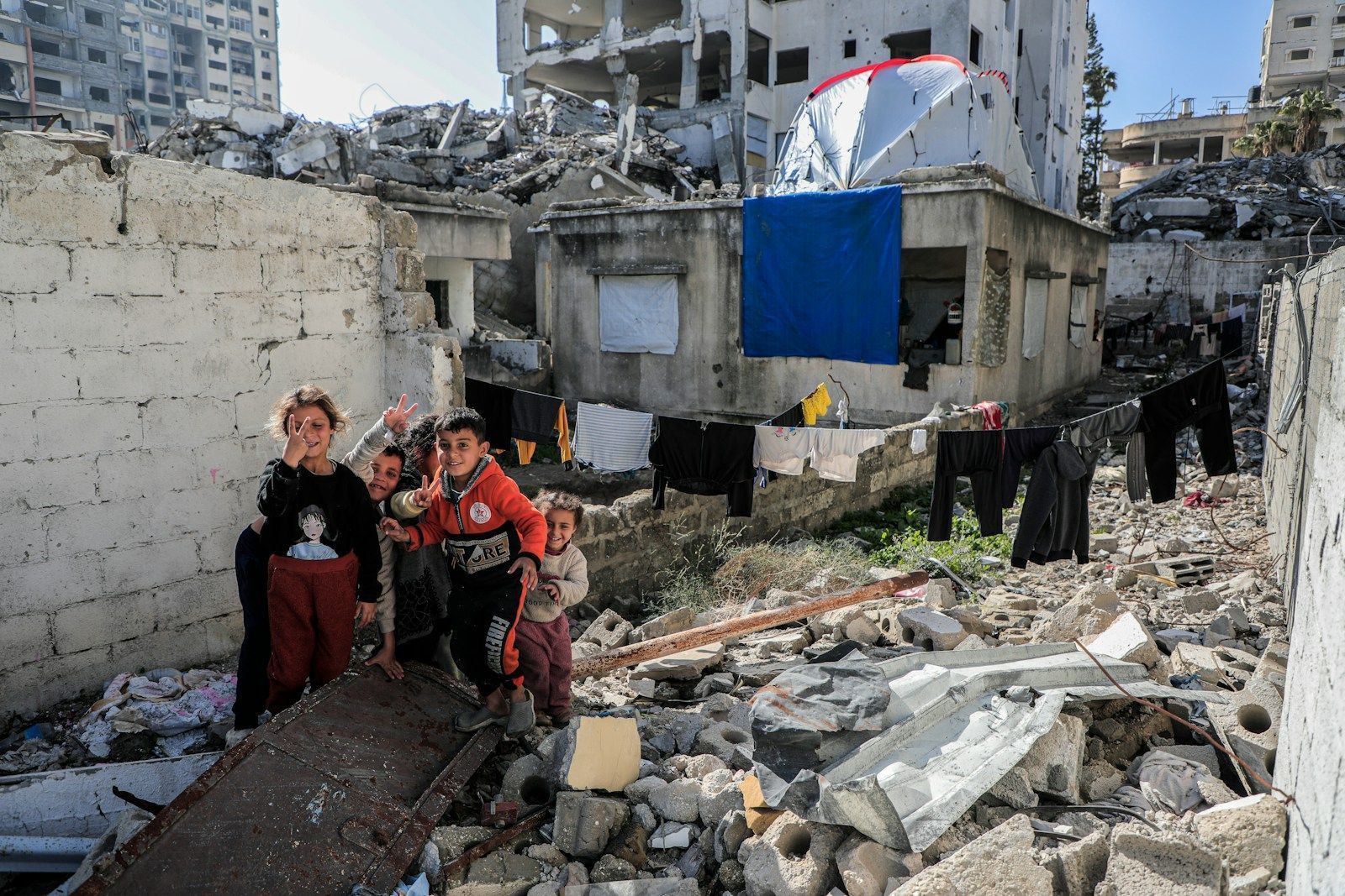 Israël et Gaza : la guerre de famine va-t-elle provoquer une crise humanitaire majeure ? A group of people standing next to a pile of rubble