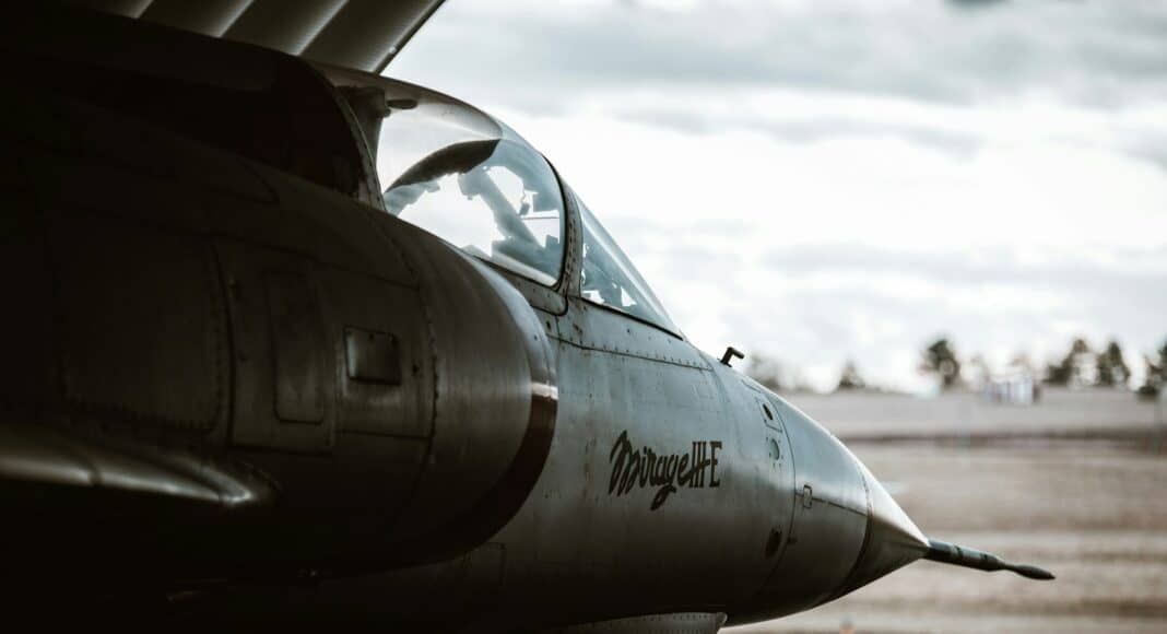 a fighter jet sitting on top of an airport tarmac