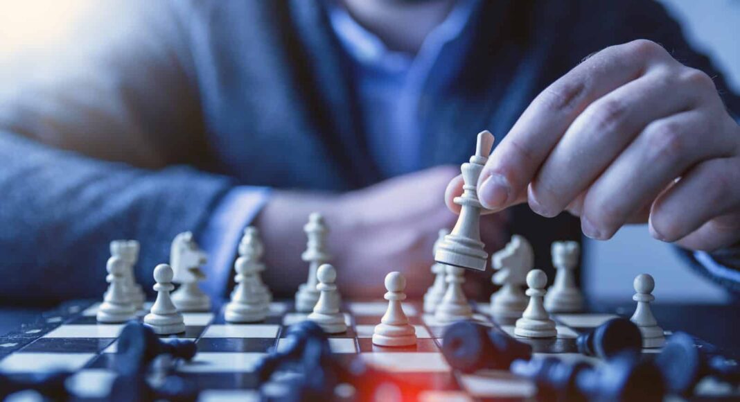 depth of field photography of man playing chess