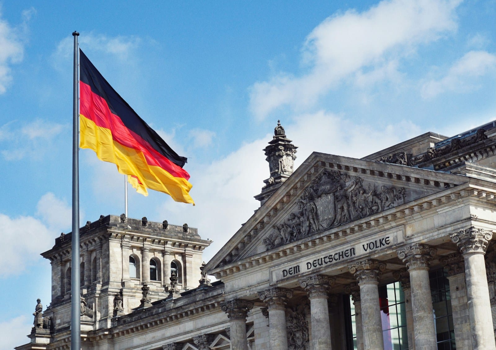 Allemagne : la transition énergétique au bord du précipice white concrete building with flags on top under blue sky during daytime
