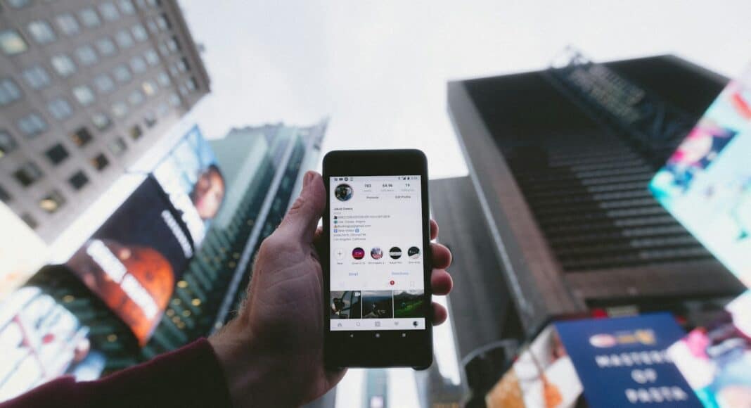 high angle photo of person holding turned on smartphone with tall buildings background