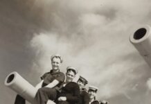 a group of men sitting on top of a giant telescope
