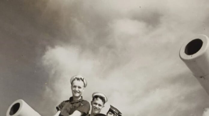 a group of men sitting on top of a giant telescope