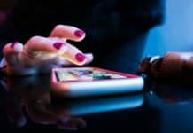 person using black smartphone with gray and pink case