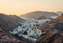 aerial view of white concrete buildings near rock cliffs