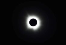 a solar eclipse is seen in the dark sky