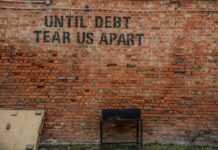 Liban : comprendre les risques systémiques de la dette publique Until debt tear us apart printed red brick wall at daytime