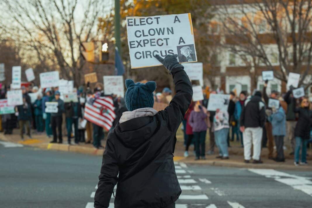 A person holding a sign in the middle of a street