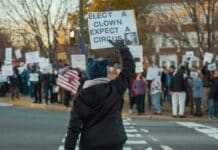 A person holding a sign in the middle of a street