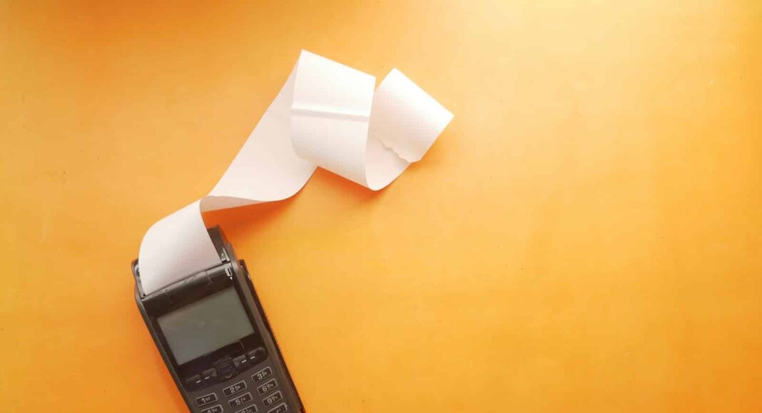 a cell phone sitting on top of a table next to a roll of paper