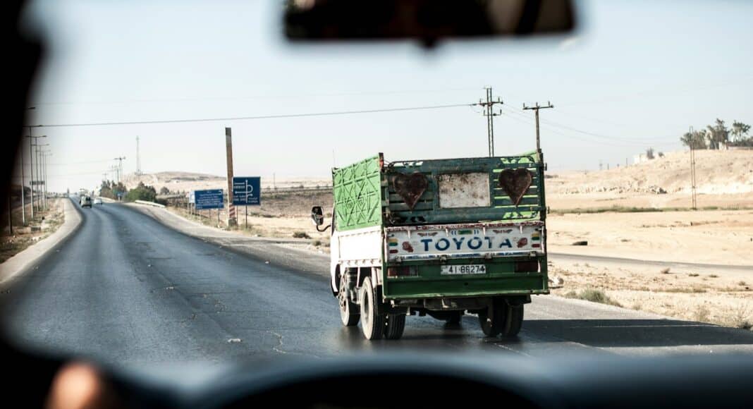 green and white Toyota truck under clear sky during daytime