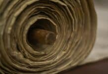 brown wooden rolling pin on white textile