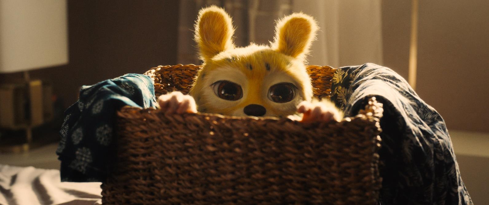 Le Marsupilami regarde par-dessus le bord d’un panier en osier, dans un visuel du film de Philippe Lacheau.